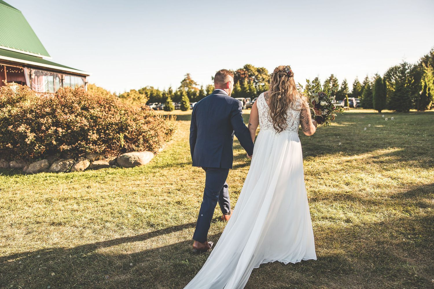 Outdoor wedding venue at sunset with white decorations and natural landscape.