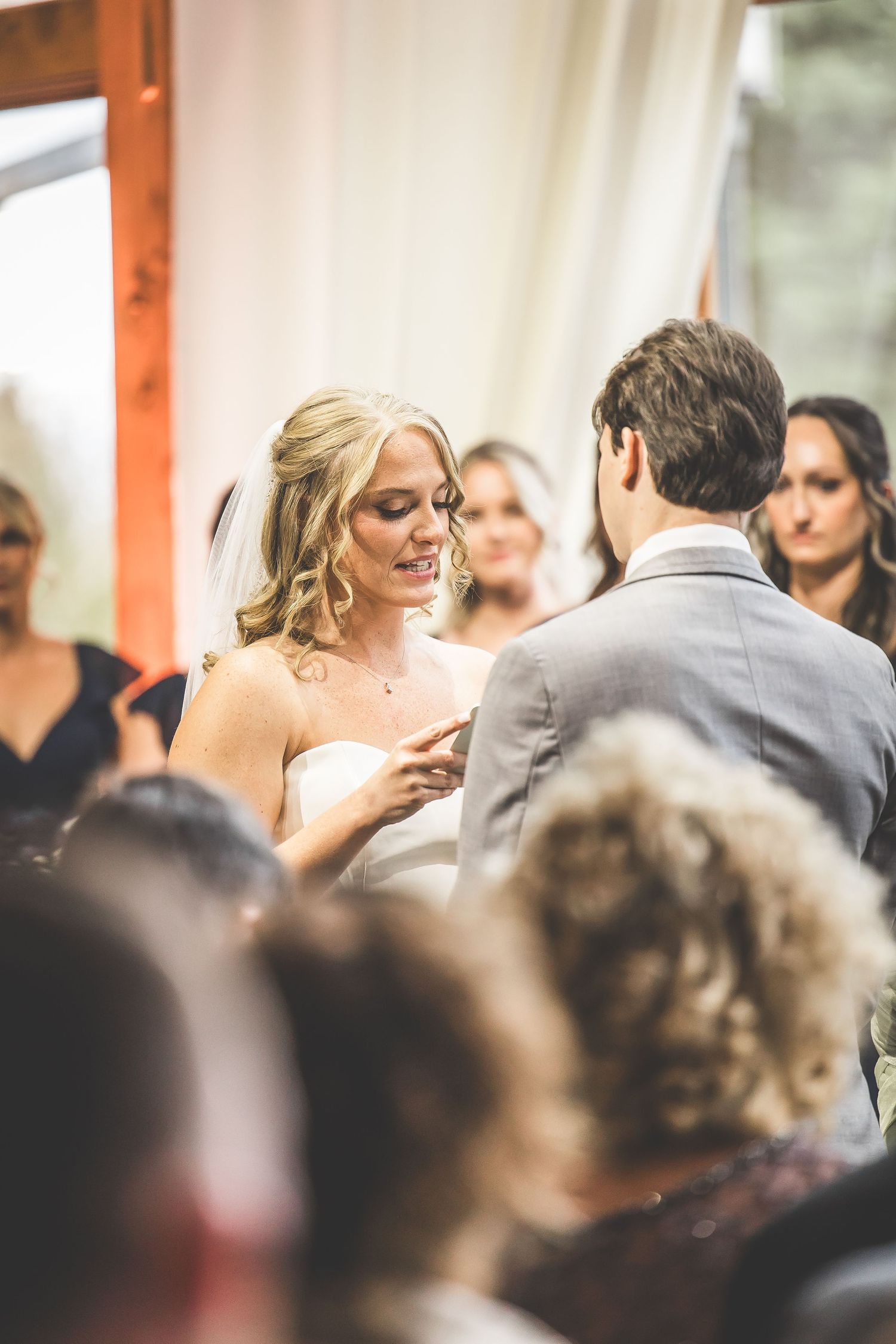 Wedding ceremony guests watch as a couple shares an intimate moment during their vows.