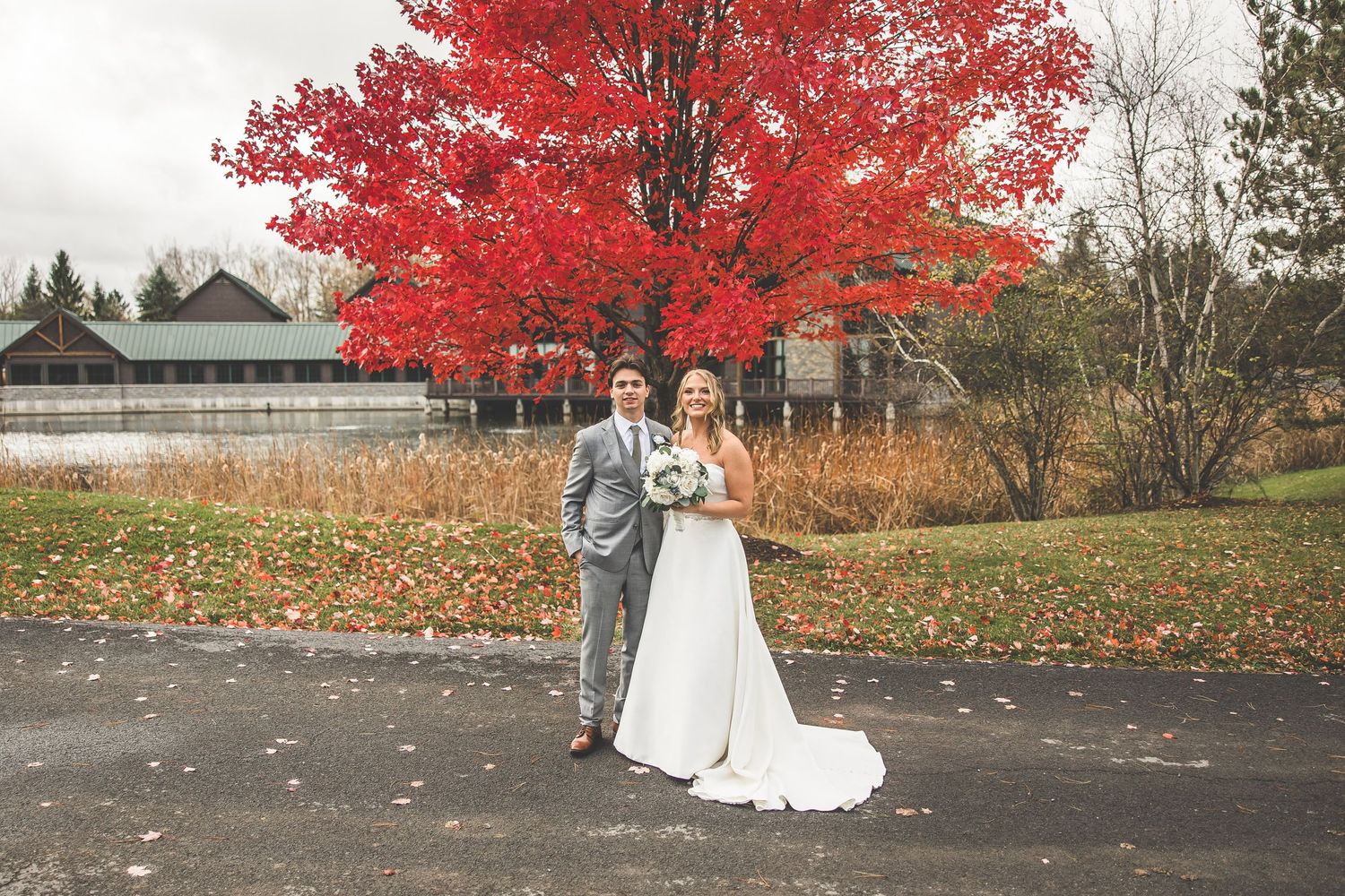 Dramatic red maple trees frame wedding venue landscape in fall.