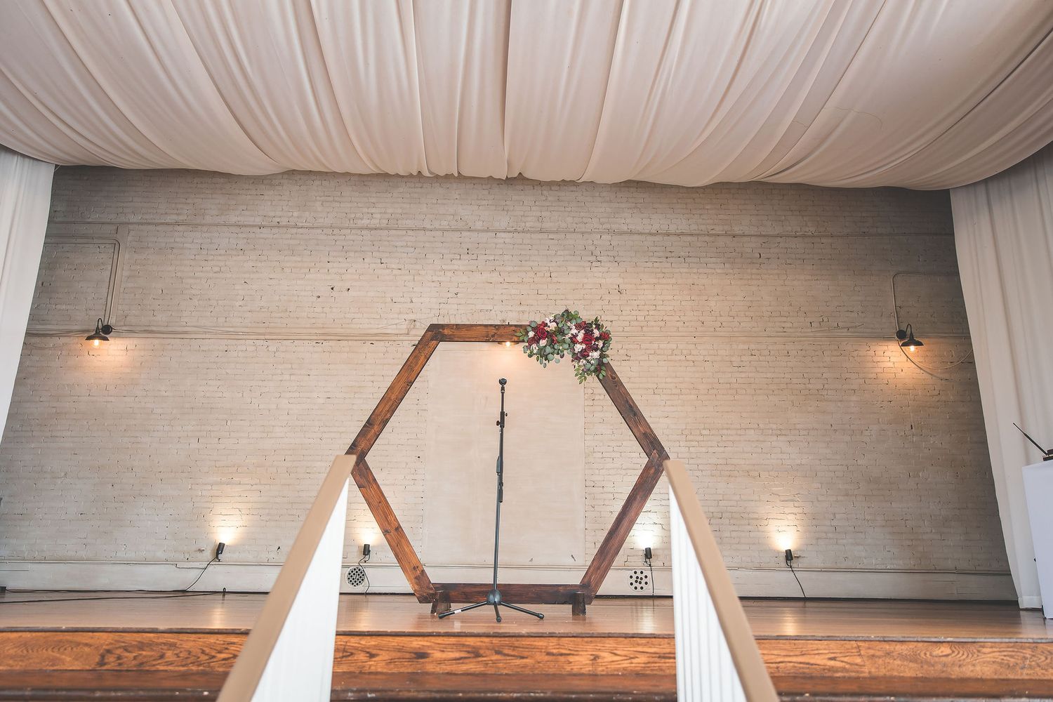 White draped ceiling with chandeliers creates an elegant wedding reception atmosphere.