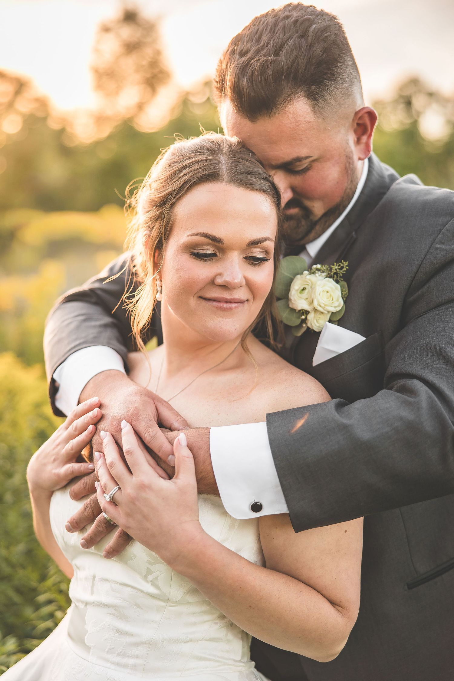 Candid wedding portraits showing tender moments between newlyweds in evening sunlight.