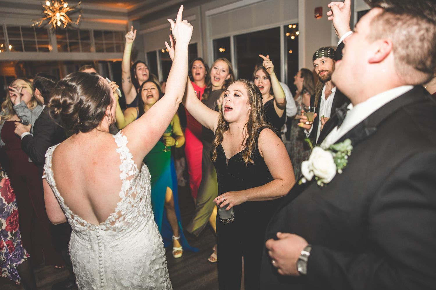 Guests dancing and celebrating during a festive indoor wedding reception party.