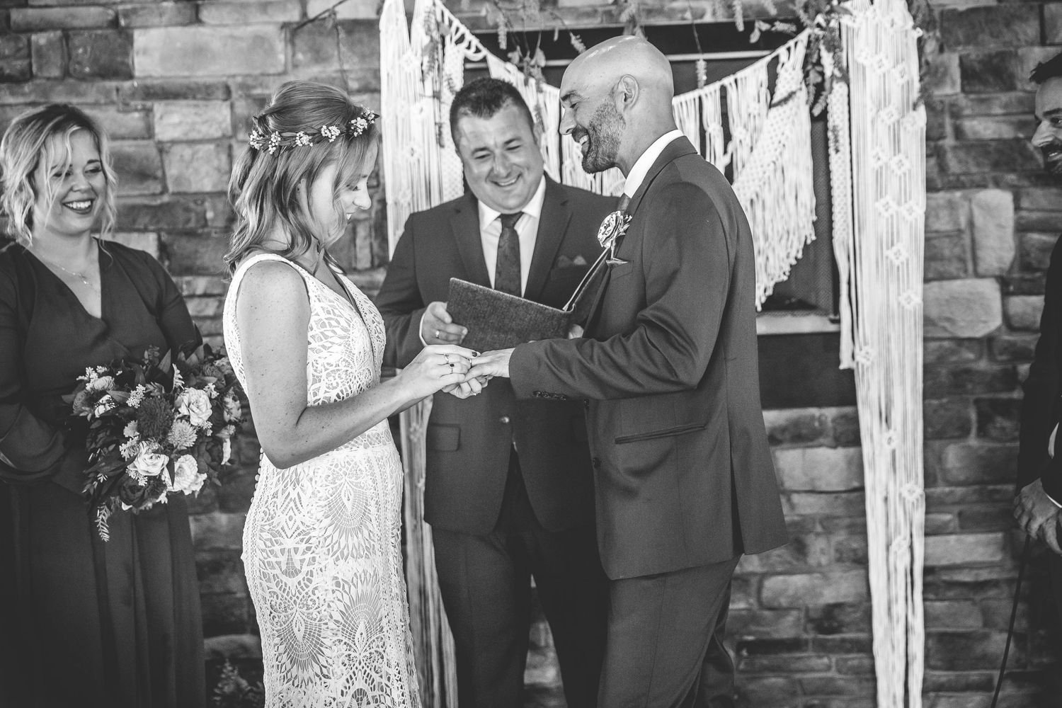 Candid wedding ceremony moments captured in front of rustic stone backdrop.