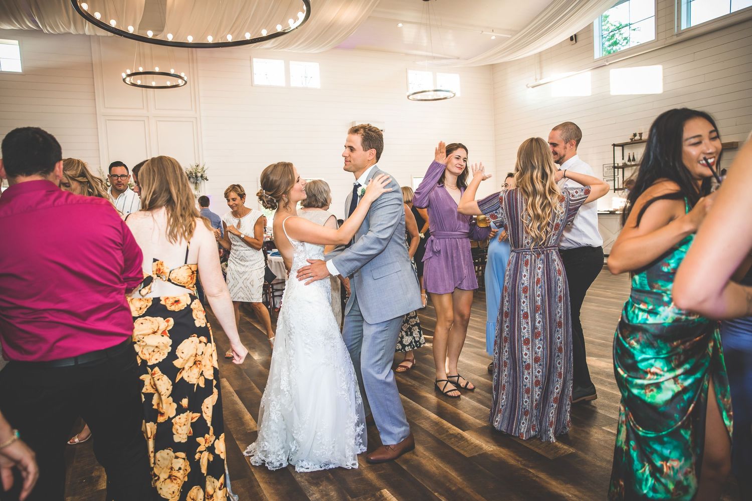 Wedding guests fill the dance floor during a lively reception celebration.