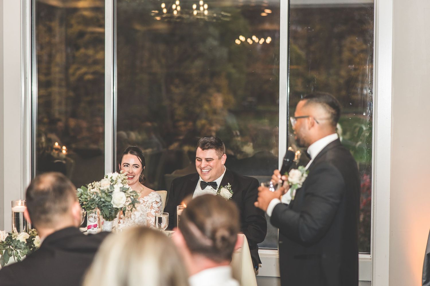 Wedding reception hall features panoramic windows and crystal chandeliers.