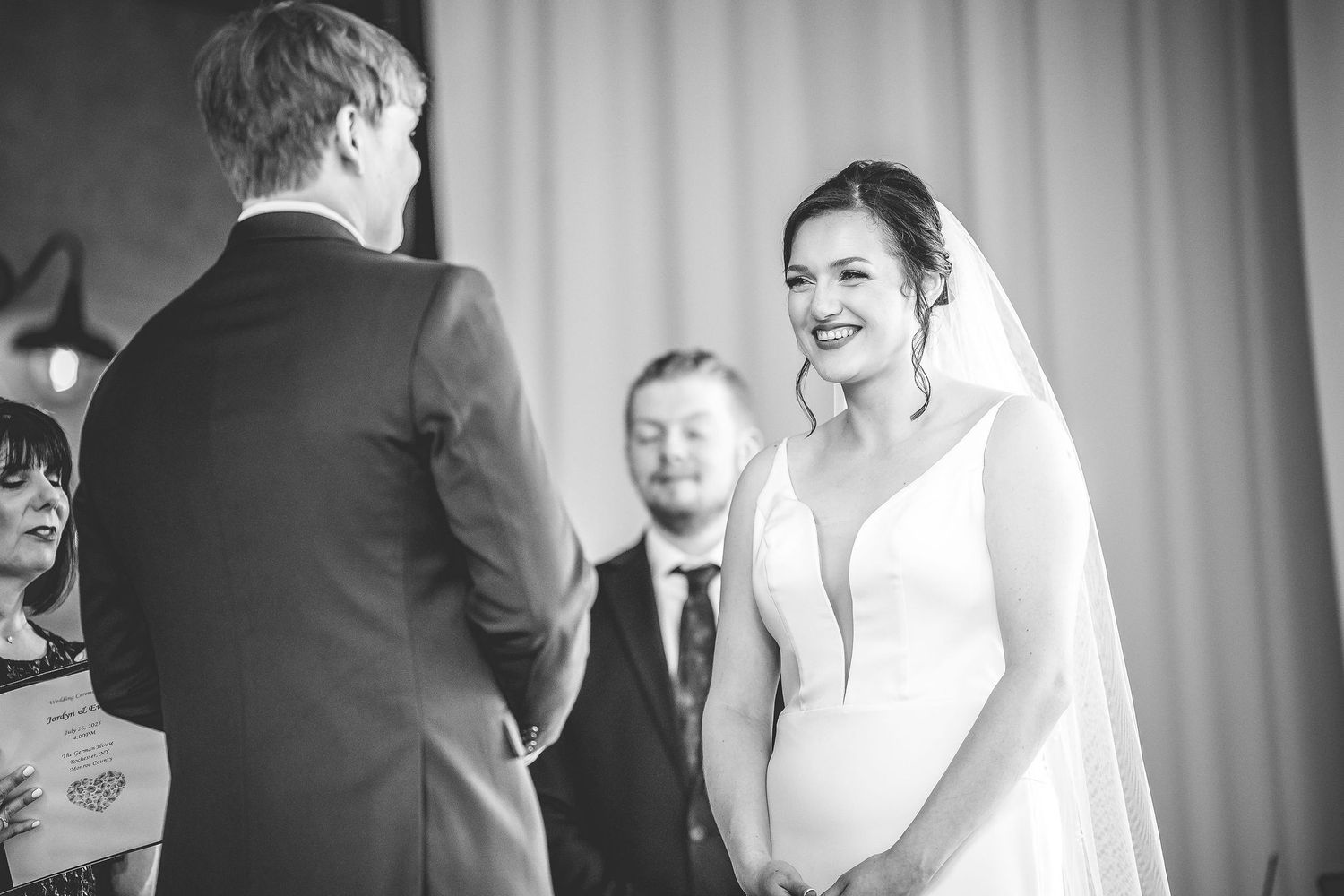 Black and white candid moments from indoor wedding ceremony.