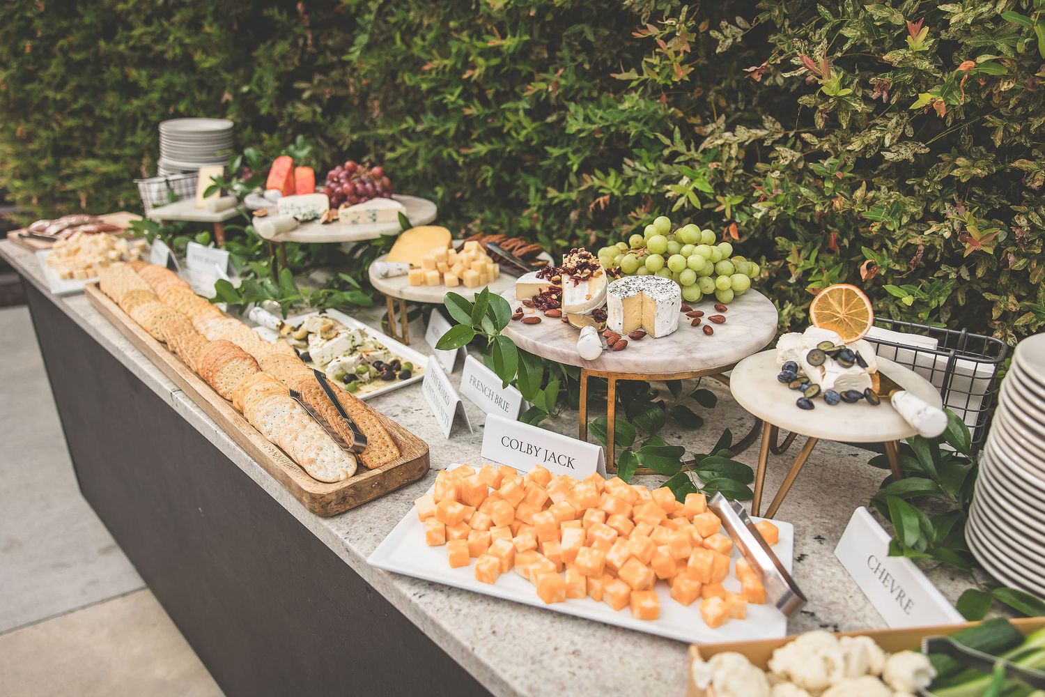 Catering display featuring appetizers, fruit, and hors d'oeuvres on elegant serving platters.