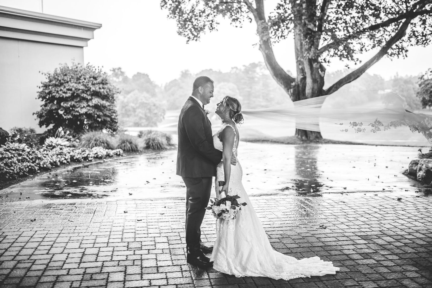 Wedding couple poses on brick pathway under trees in romantic sequence.