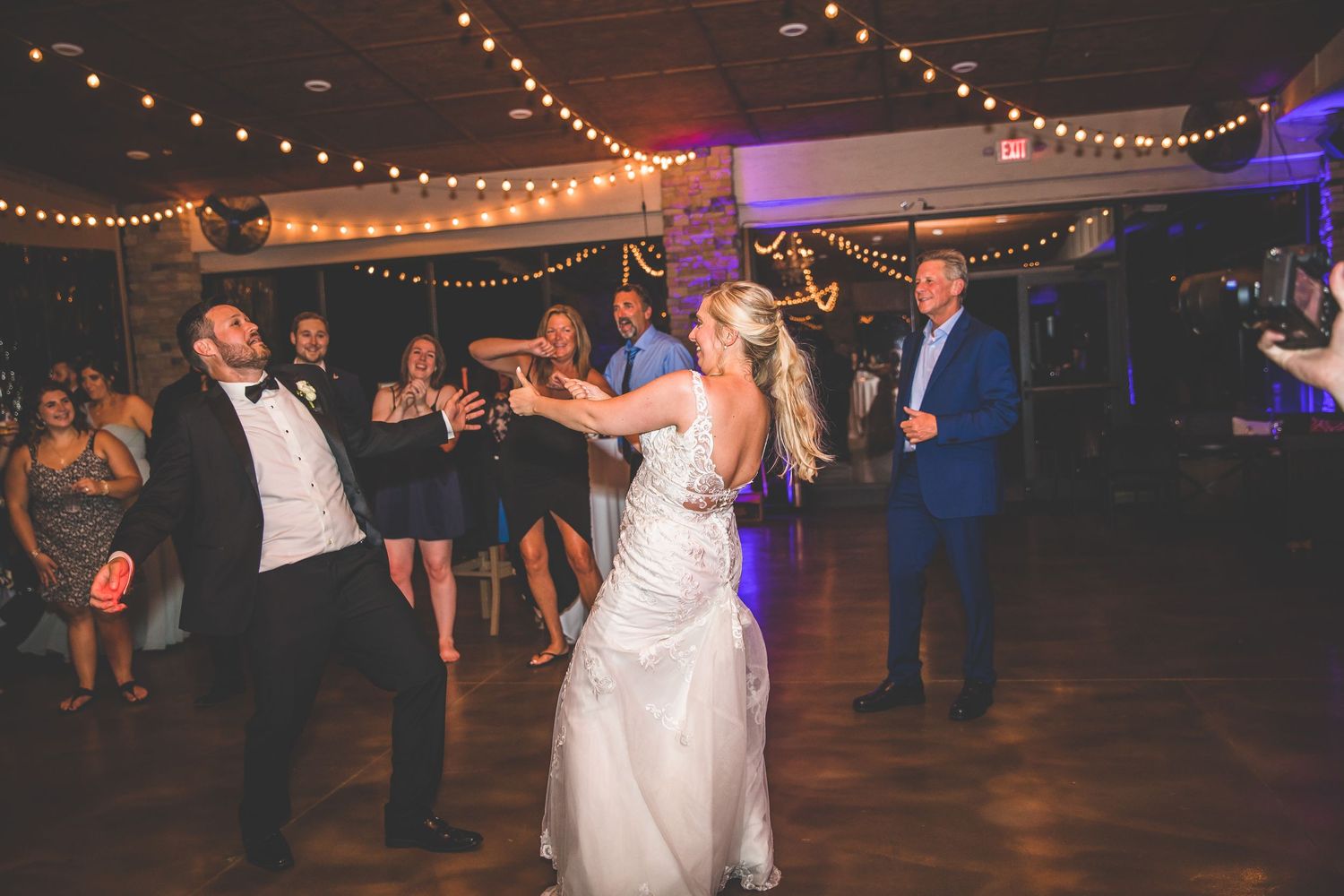 Wedding celebration on the dance floor with string lights overhead.