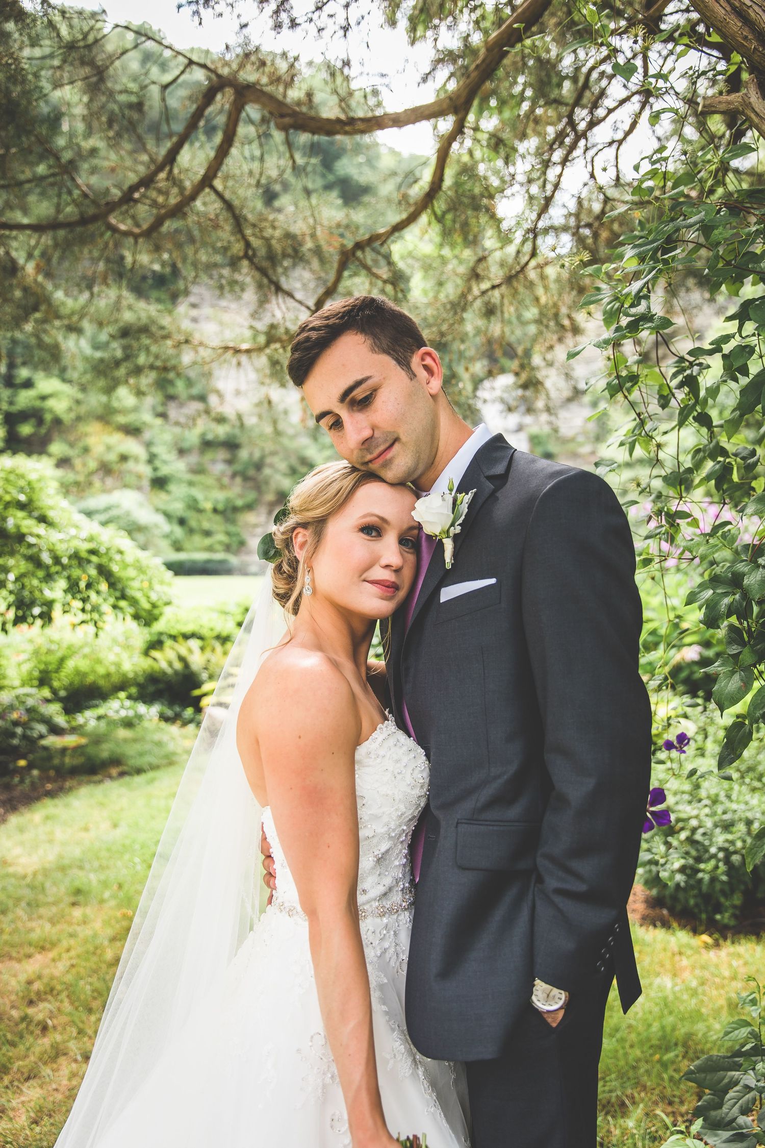 Romantic garden wedding portraits captured among lush greenery and trees.