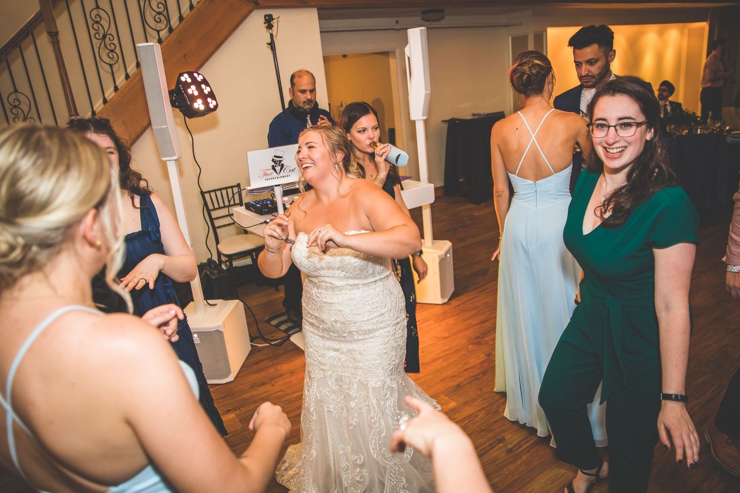 Wedding guests dance and celebrate on a wooden dance floor during the reception.