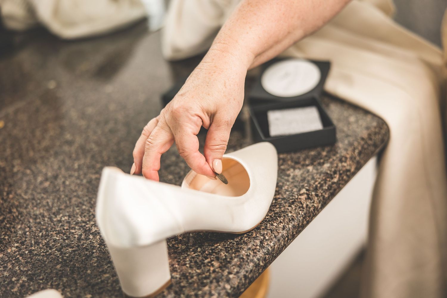 Close-up shots of hands arranging items on a dark countertop surface.