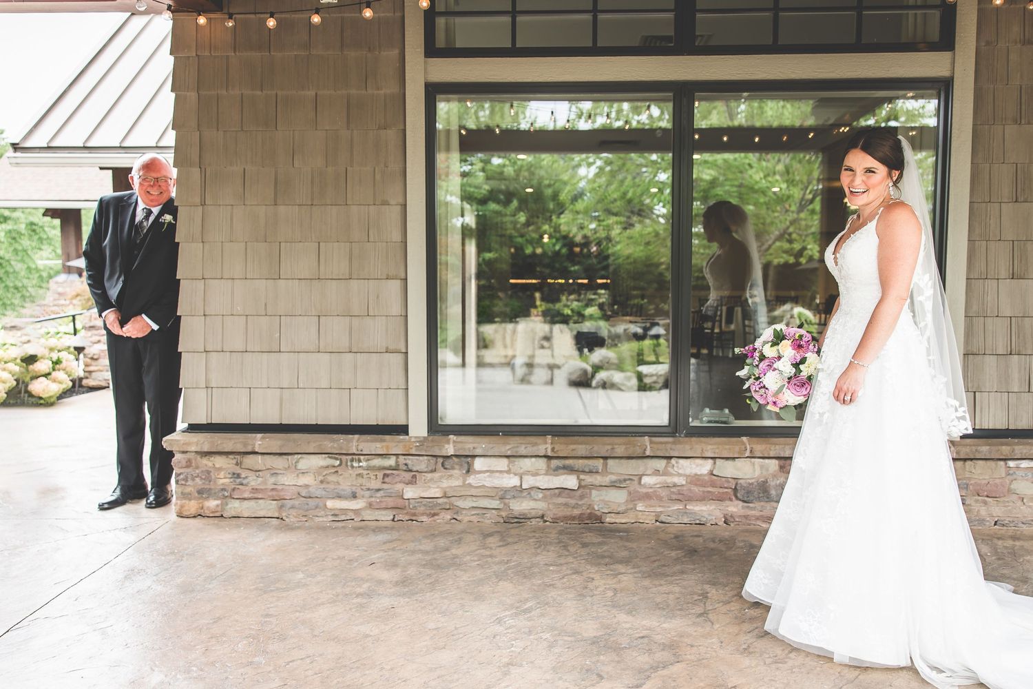 Elegant wedding venue with stone pillars and covered walkway decorated with string lights.