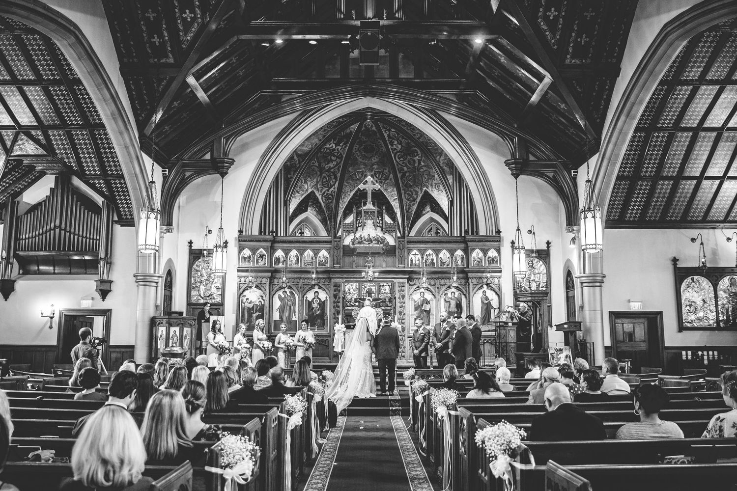 Wide angle panoramic view of a gothic church interior during a wedding ceremony.