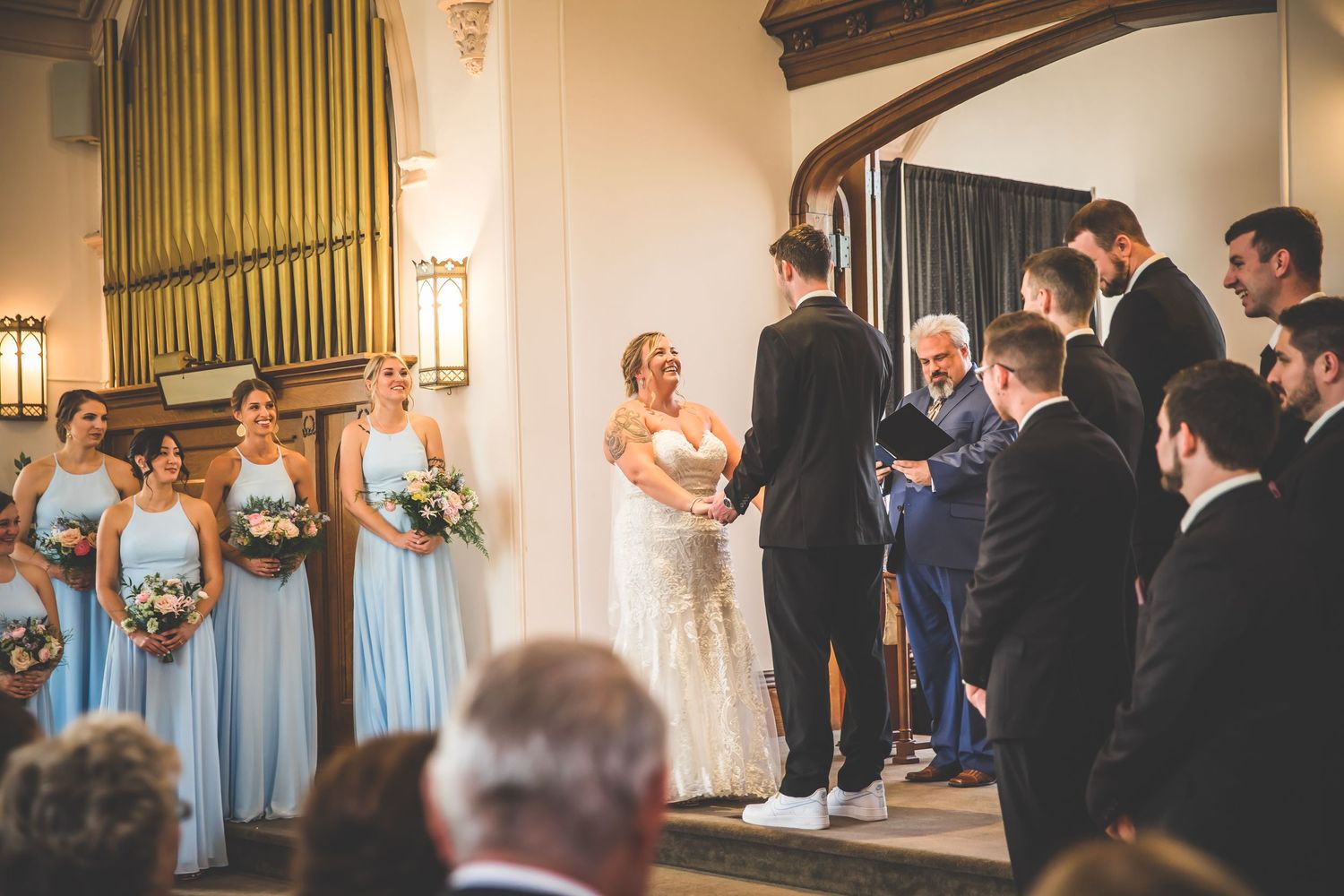 Church wedding ceremony with decorative organ pipes and elegant lighting.