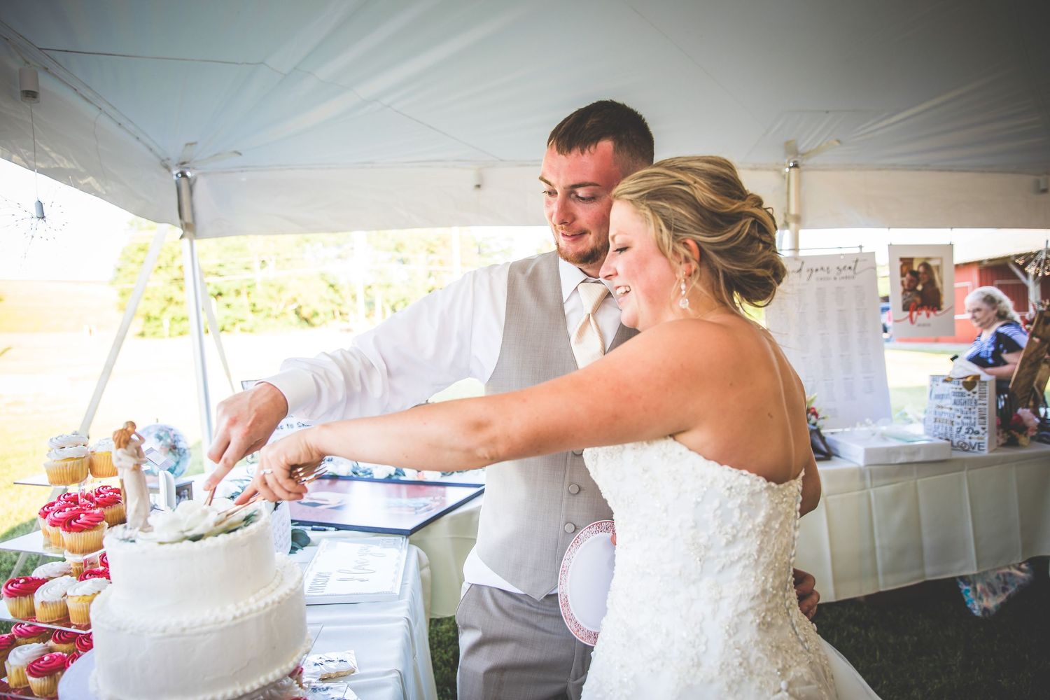 Wedding couple cutting their traditional white wedding cake at reception.