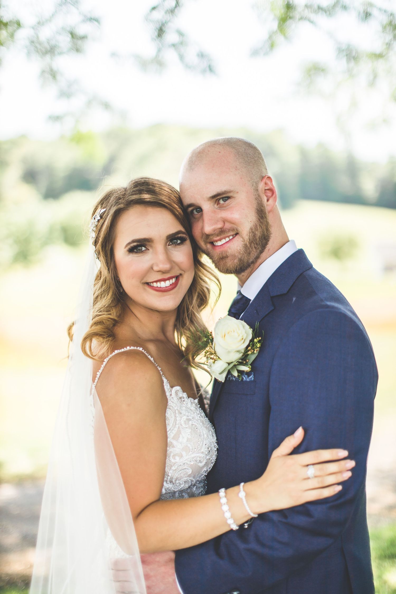 Outdoor wedding portraits in soft natural lighting with greenery background.