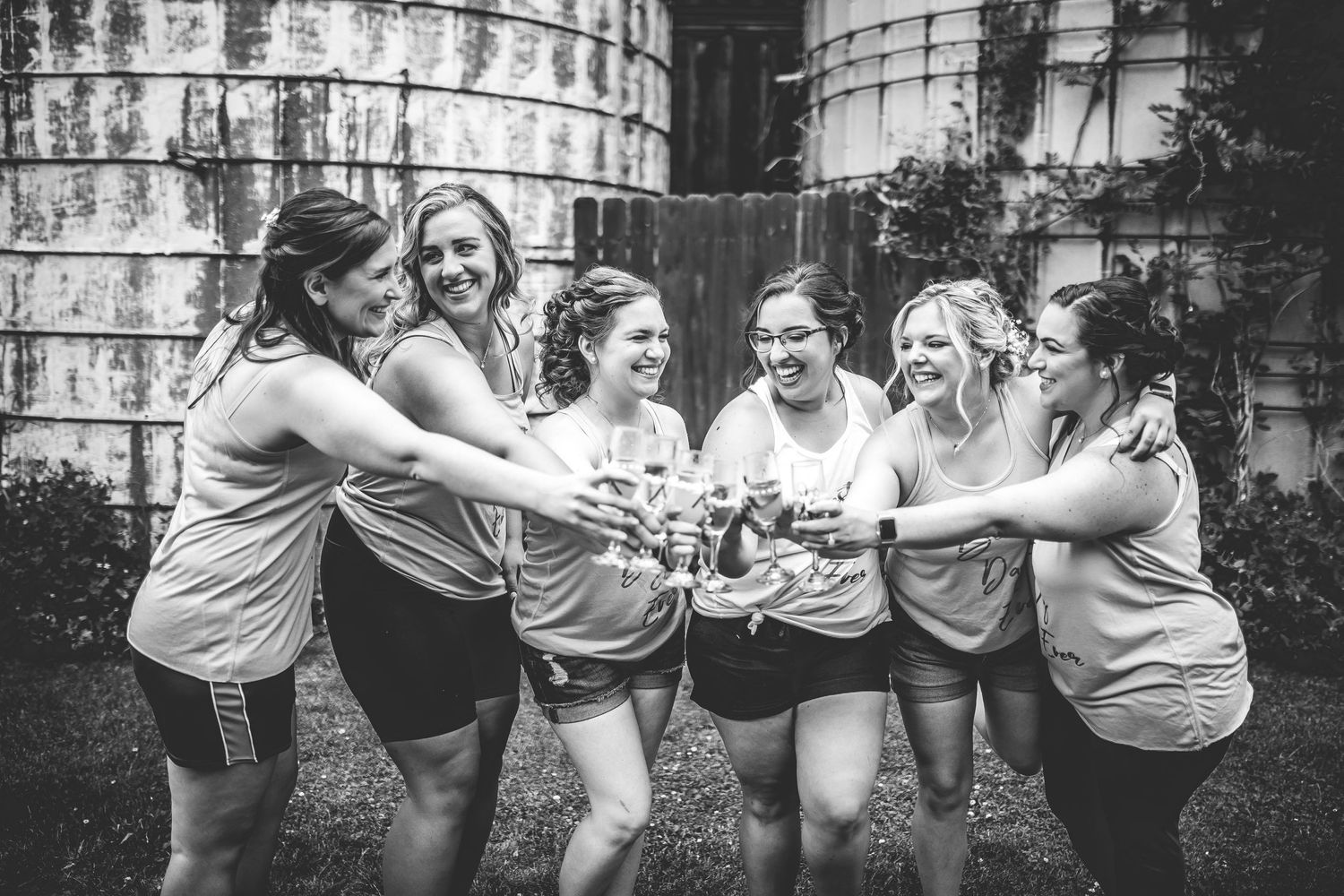 Group of people dancing and celebrating at an outdoor event in black and white.