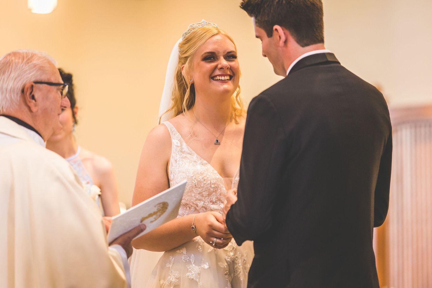 Wedding party members in formal attire gathered during ceremony.