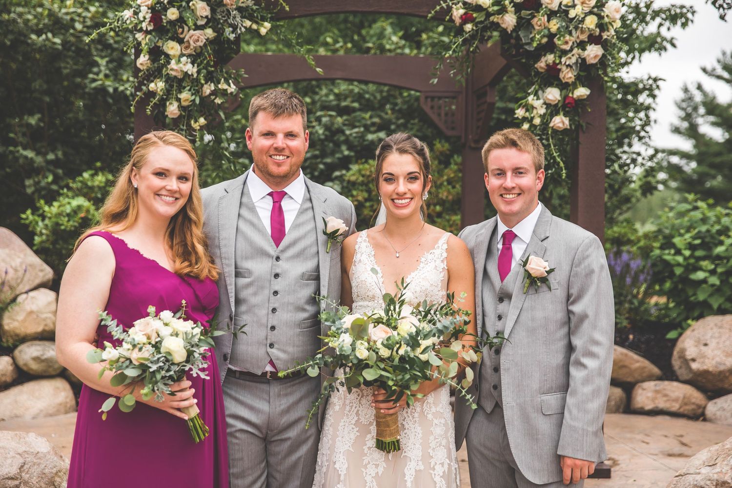 Wedding party members in grey suits and colorful dresses gather for group photos.