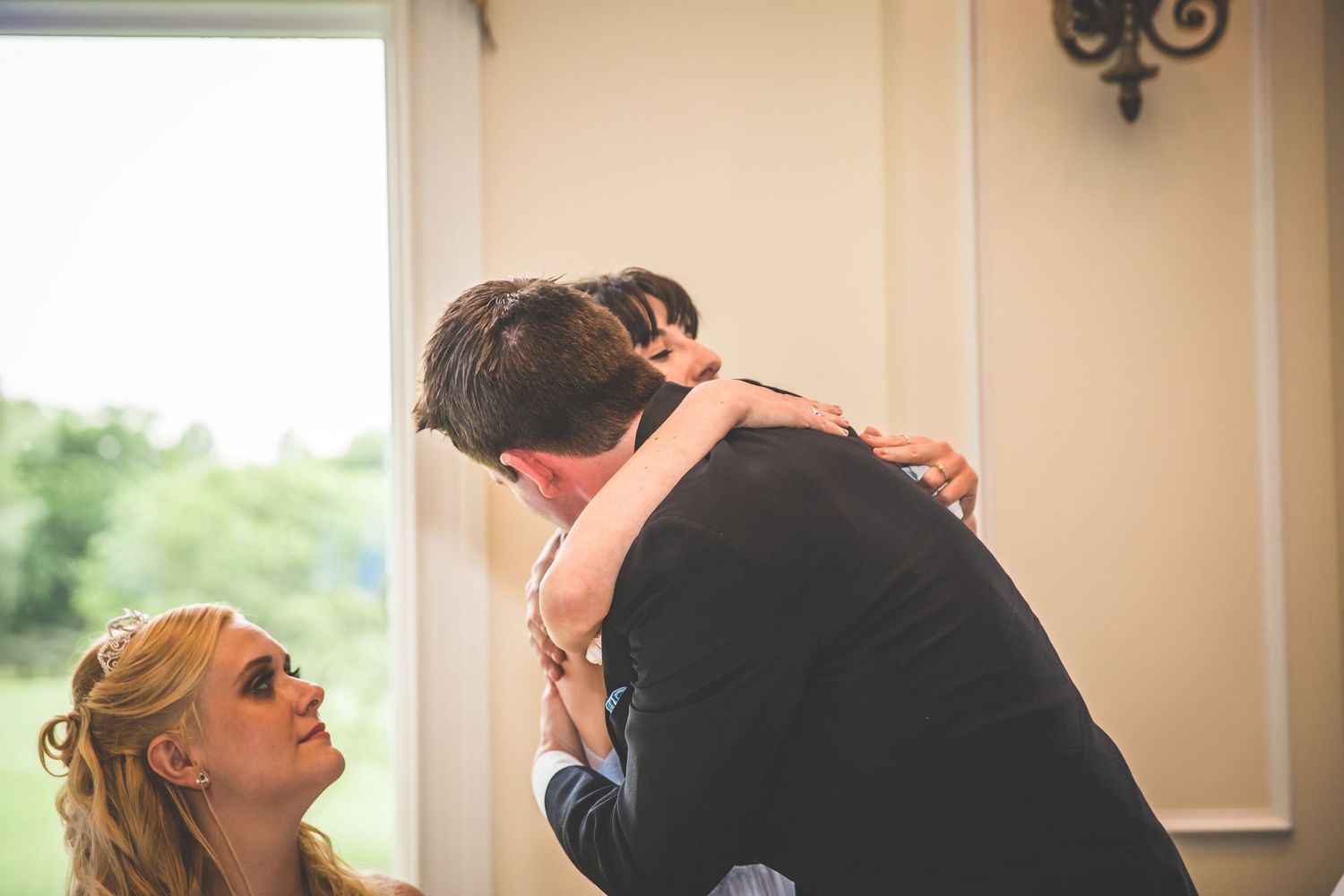 Emotional candid moments shared between wedding guests during reception dinner.