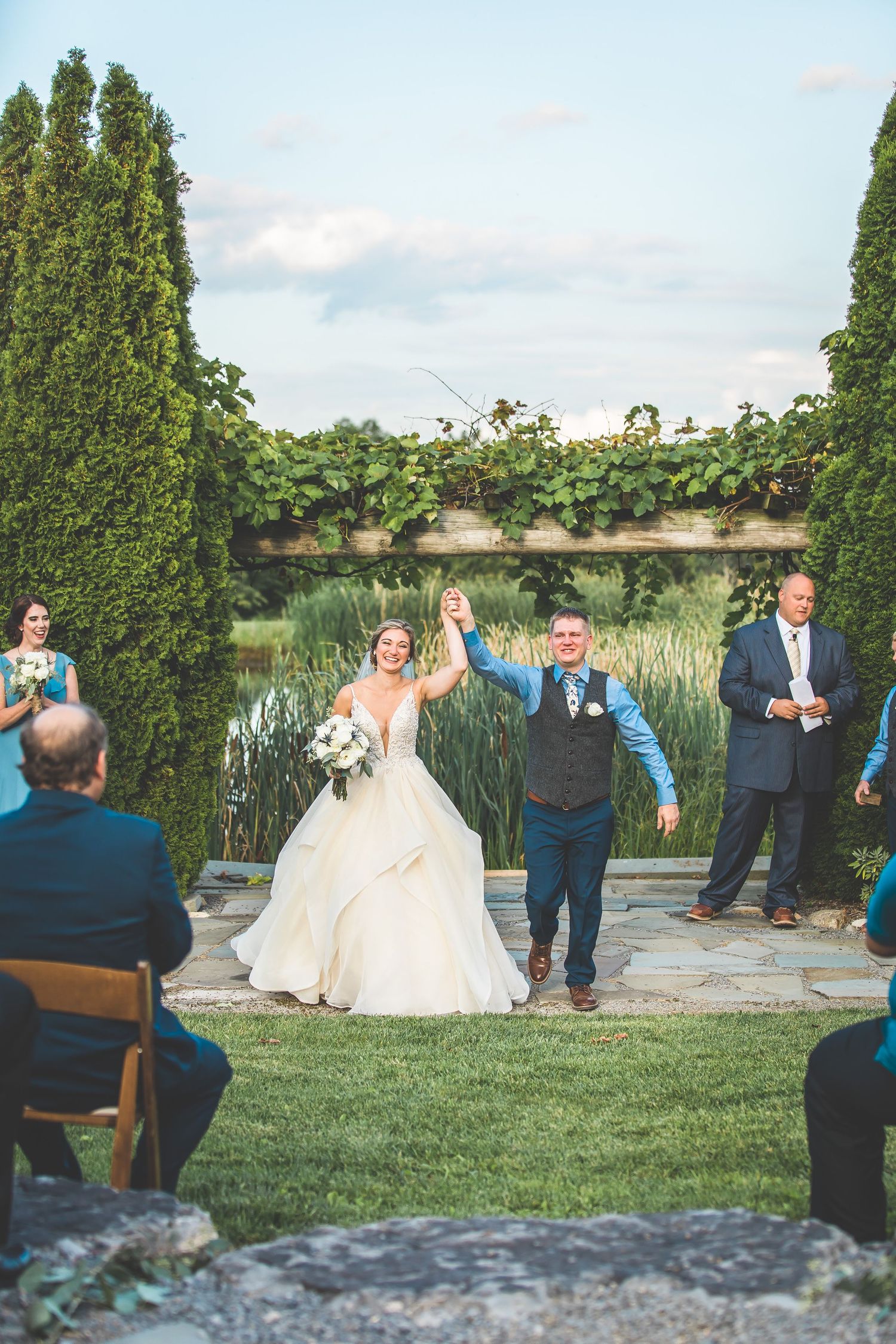 Wedding ceremony setup outdoors with tall cypress trees and a natural backdrop.