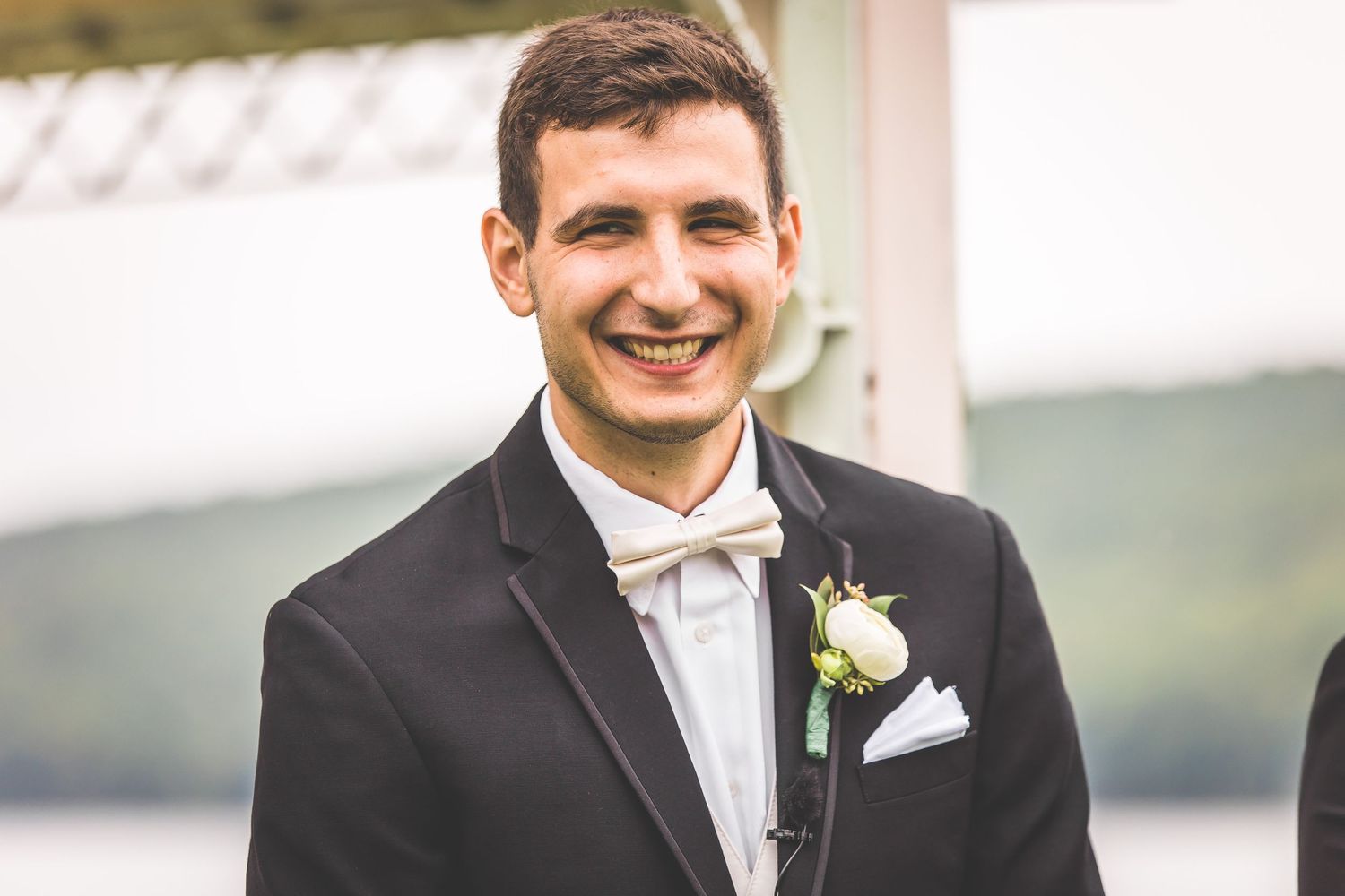 Wedding party members in formal attire share joyful moments outdoors.
