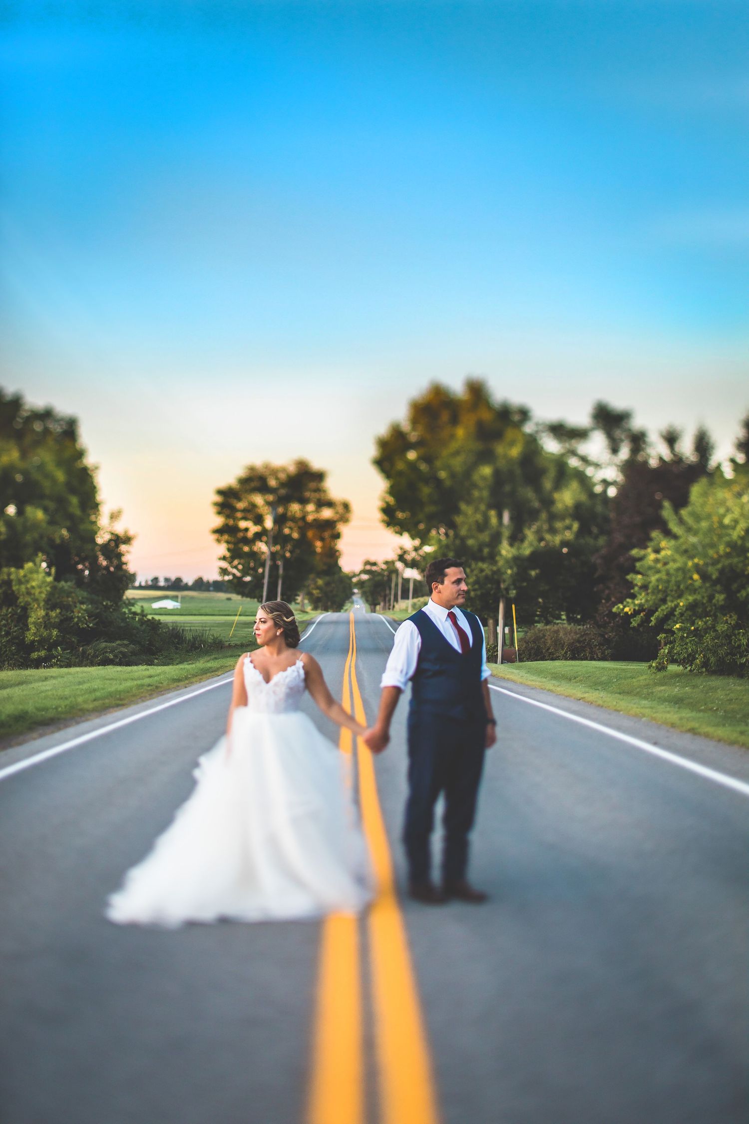 Creative wedding photo sequence on empty road with couple walking into sunset.