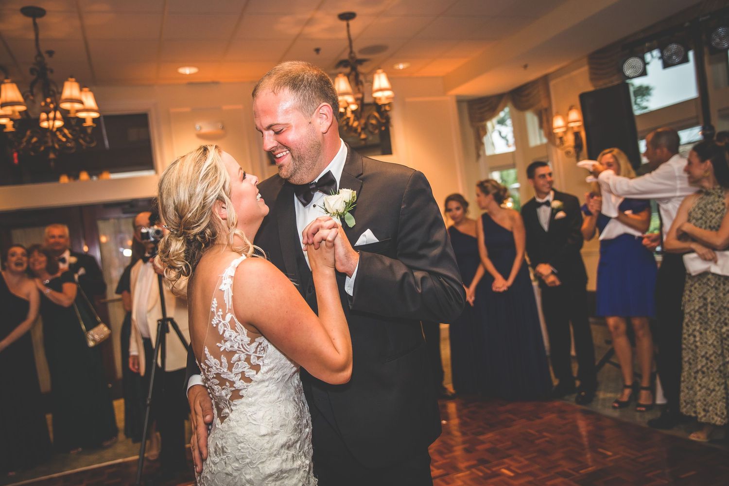 Couple shares an intimate dance moment under warm lighting at their wedding reception.
