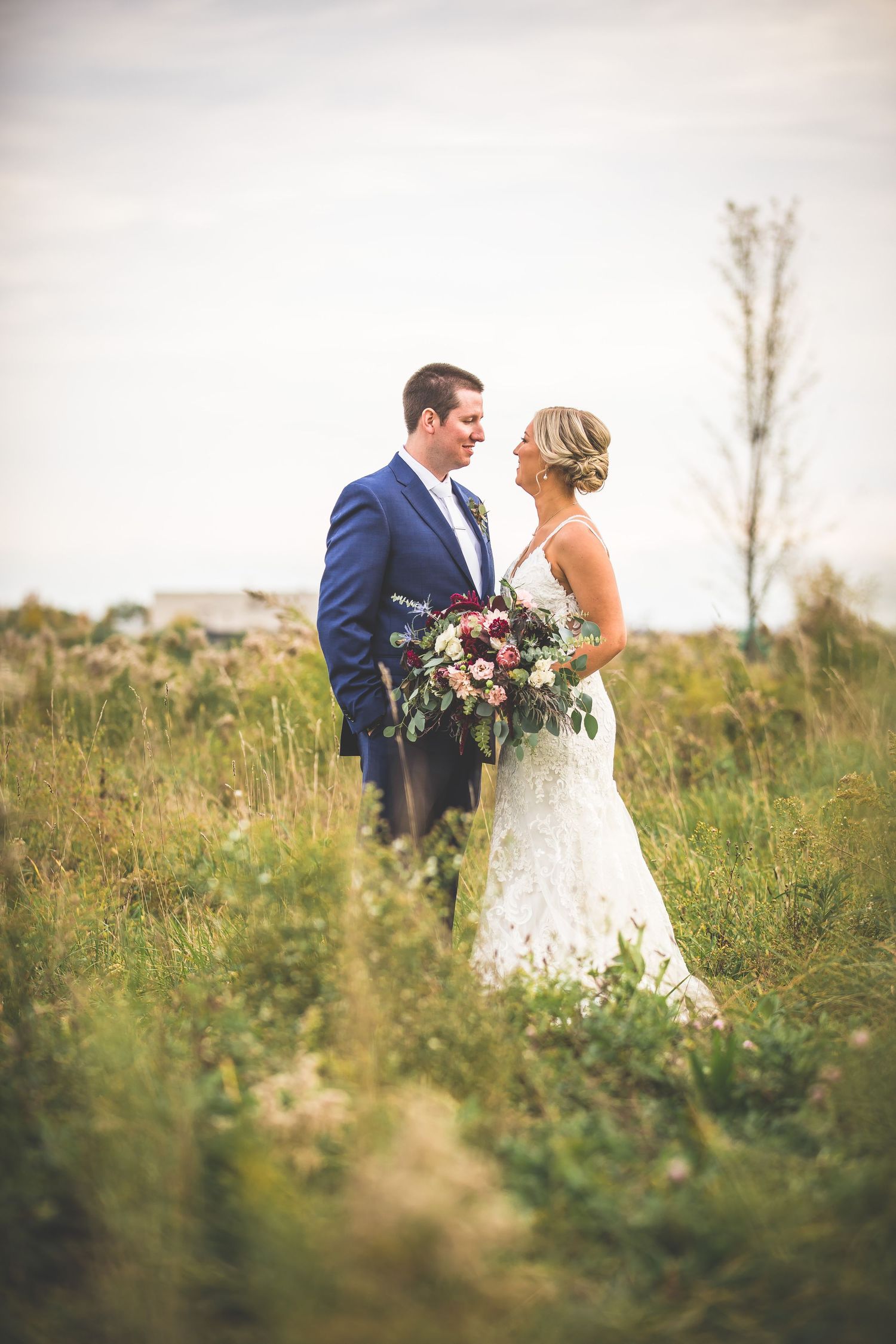 Couple shares romantic moment in wildflower field during wedding photoshoot.