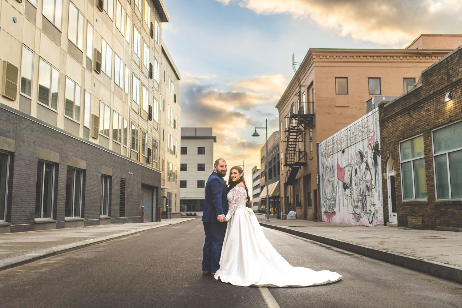Panoramic wedding photos at sunset showing couple against urban cityscape backdrop.