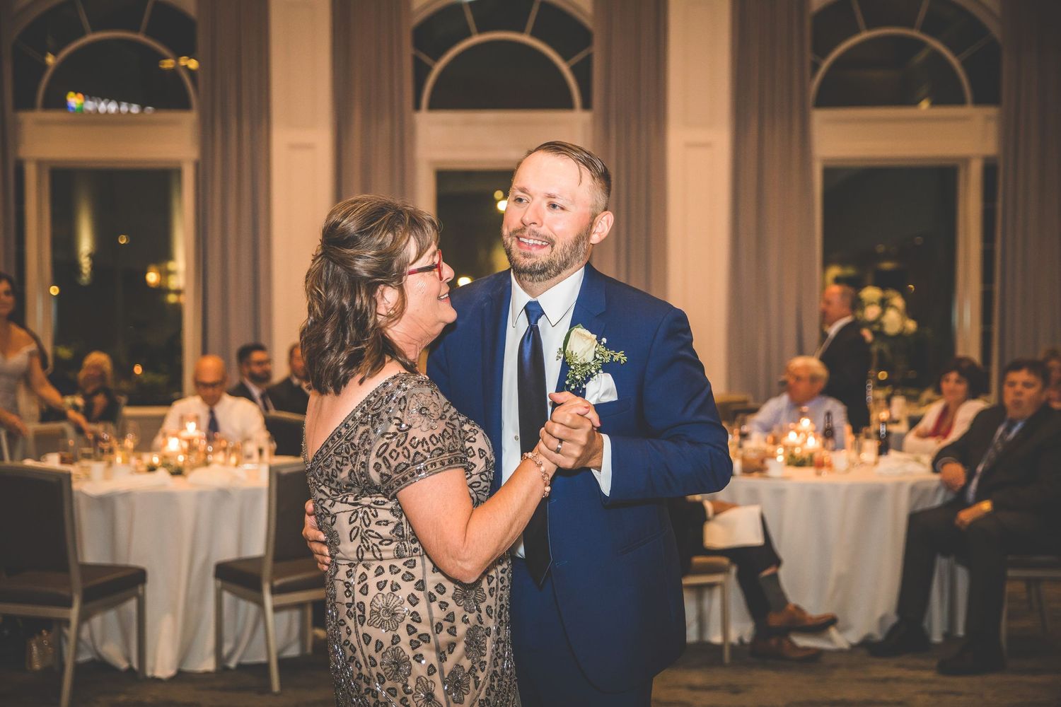 Evening wedding celebration with guests dancing in an elegant venue.