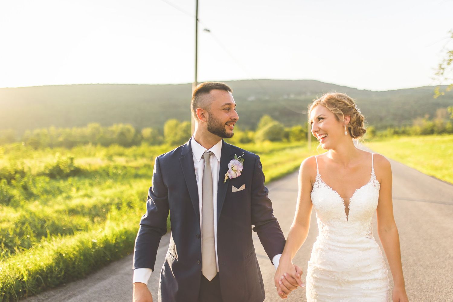 Joyful wedding couple celebrating on a scenic rural road.