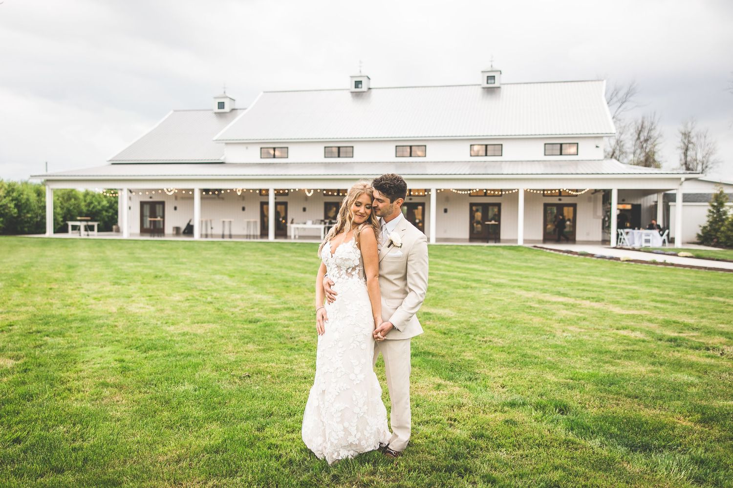 Elegant white wedding venue exterior with landscaped lawn and classic architectural details.