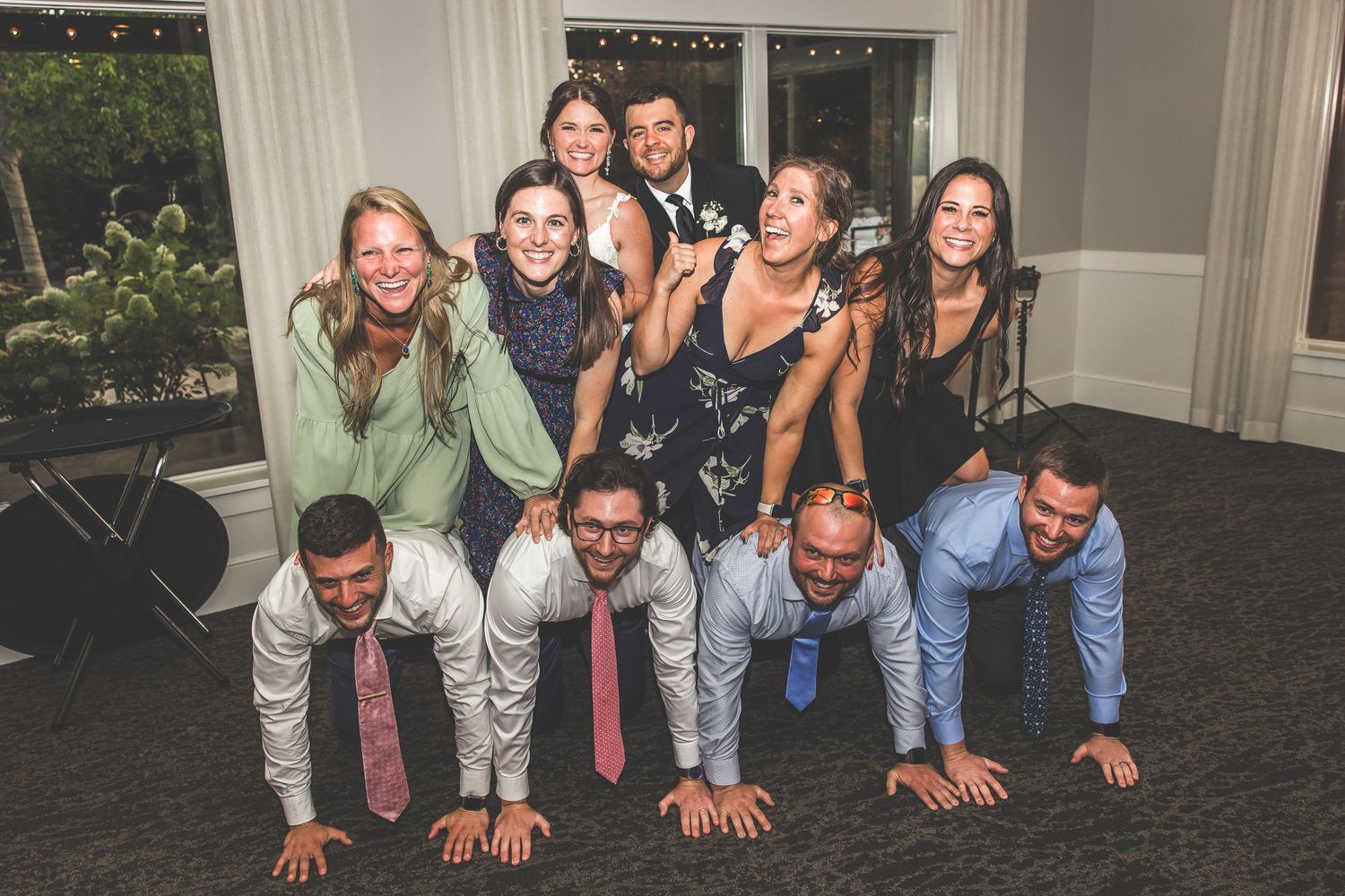Wedding party poses for fun group photo on the dance floor.
