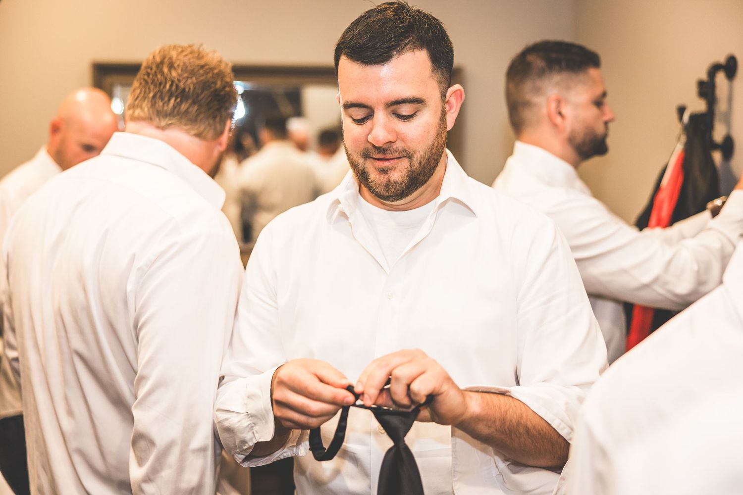 Groomsmen in white shirts sharing a lighthearted moment before the ceremony.