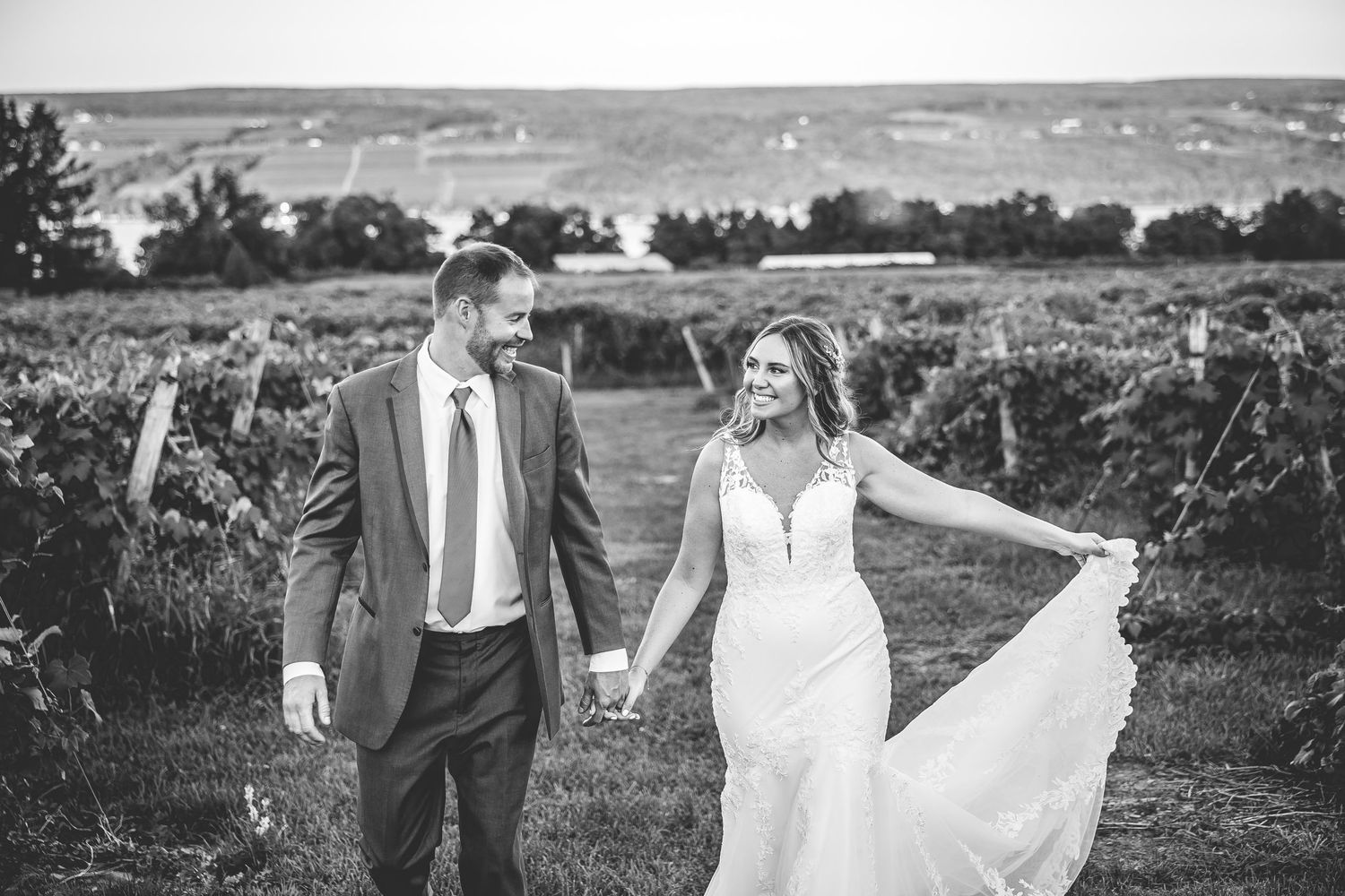 Couple walking together in a scenic outdoor setting on their wedding day.