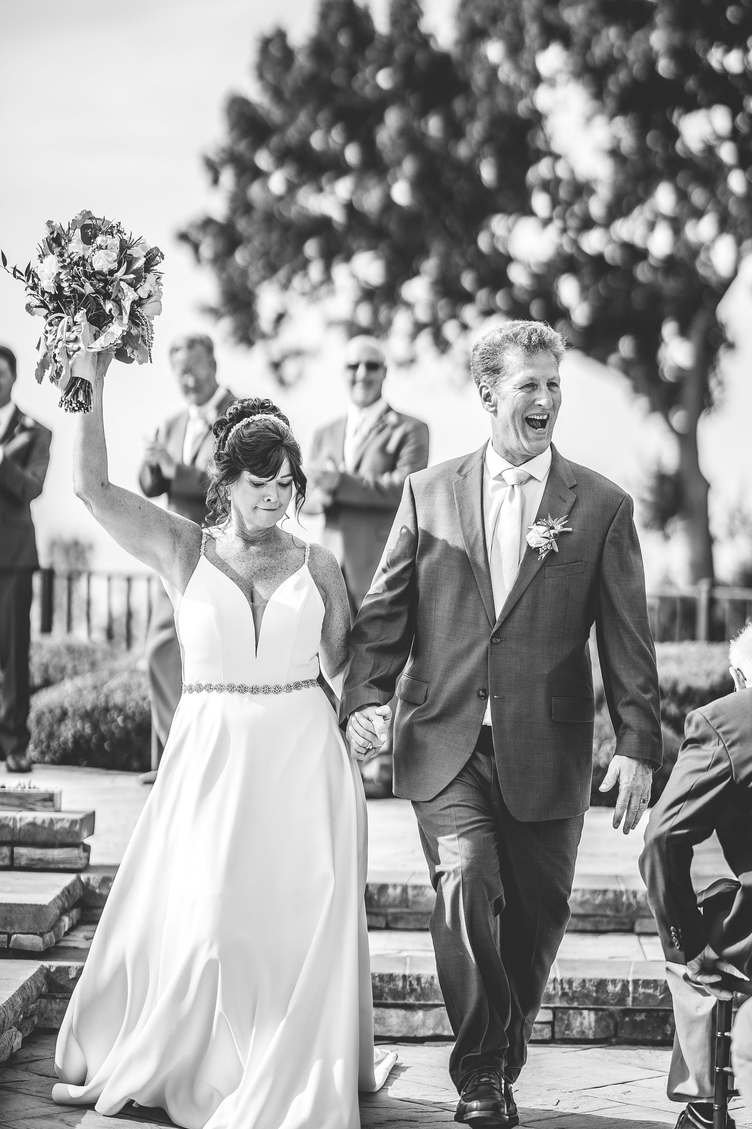 Black and white candid shots of wedding party walking and celebrating outdoors.