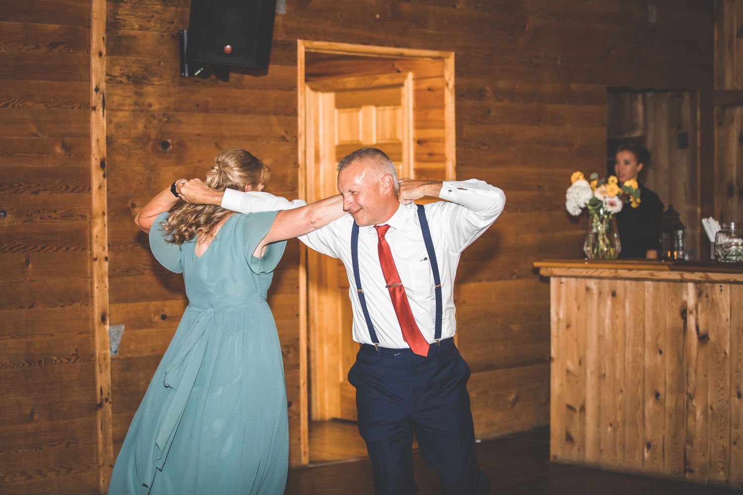 Guests dancing and celebrating at rustic barn wedding reception.