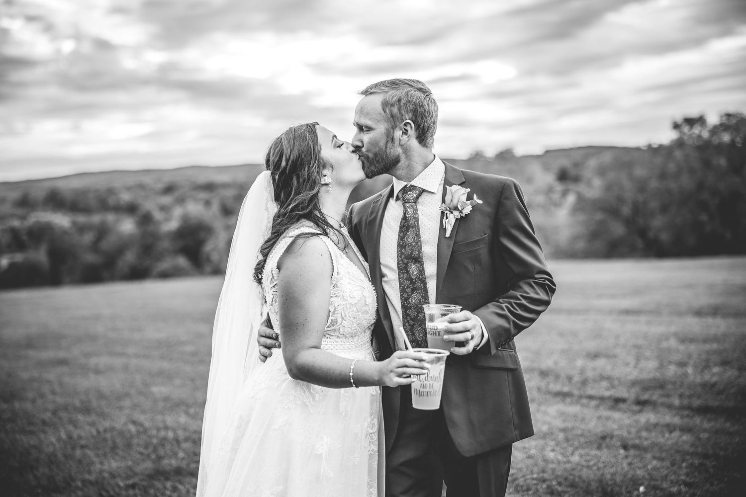 Black and white wedding portraits capture romantic moments in a scenic countryside setting.