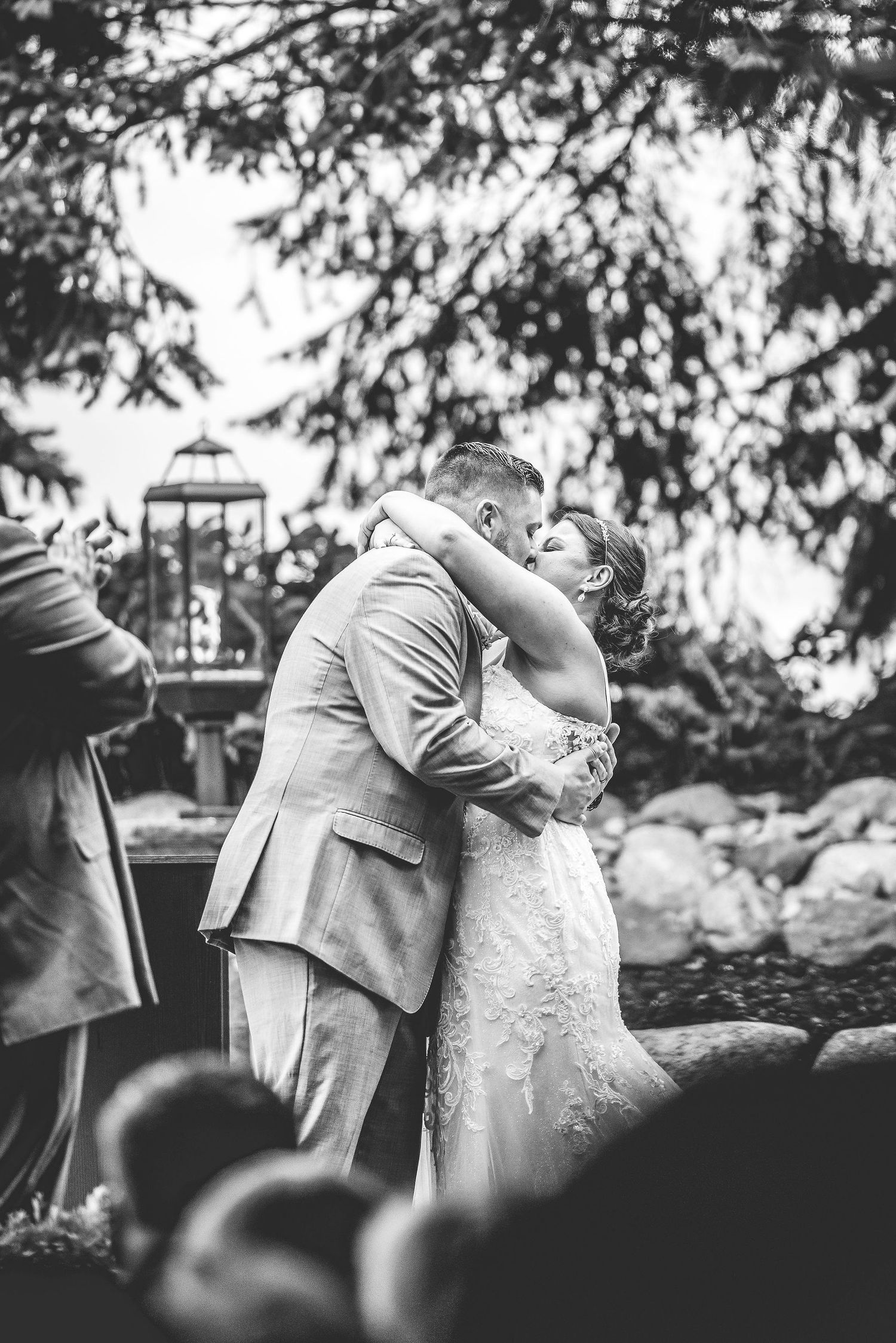 Romantic dance moves captured during outdoor wedding celebration near stone wall.