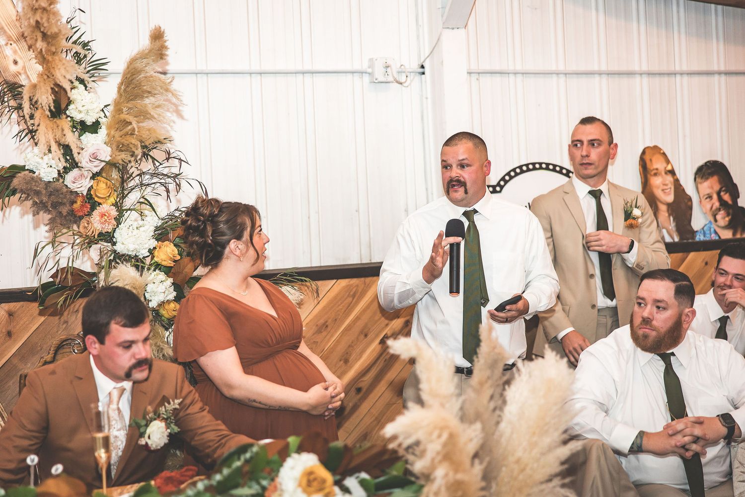 Wedding party celebrates with laughter and joy at rustic-themed reception.