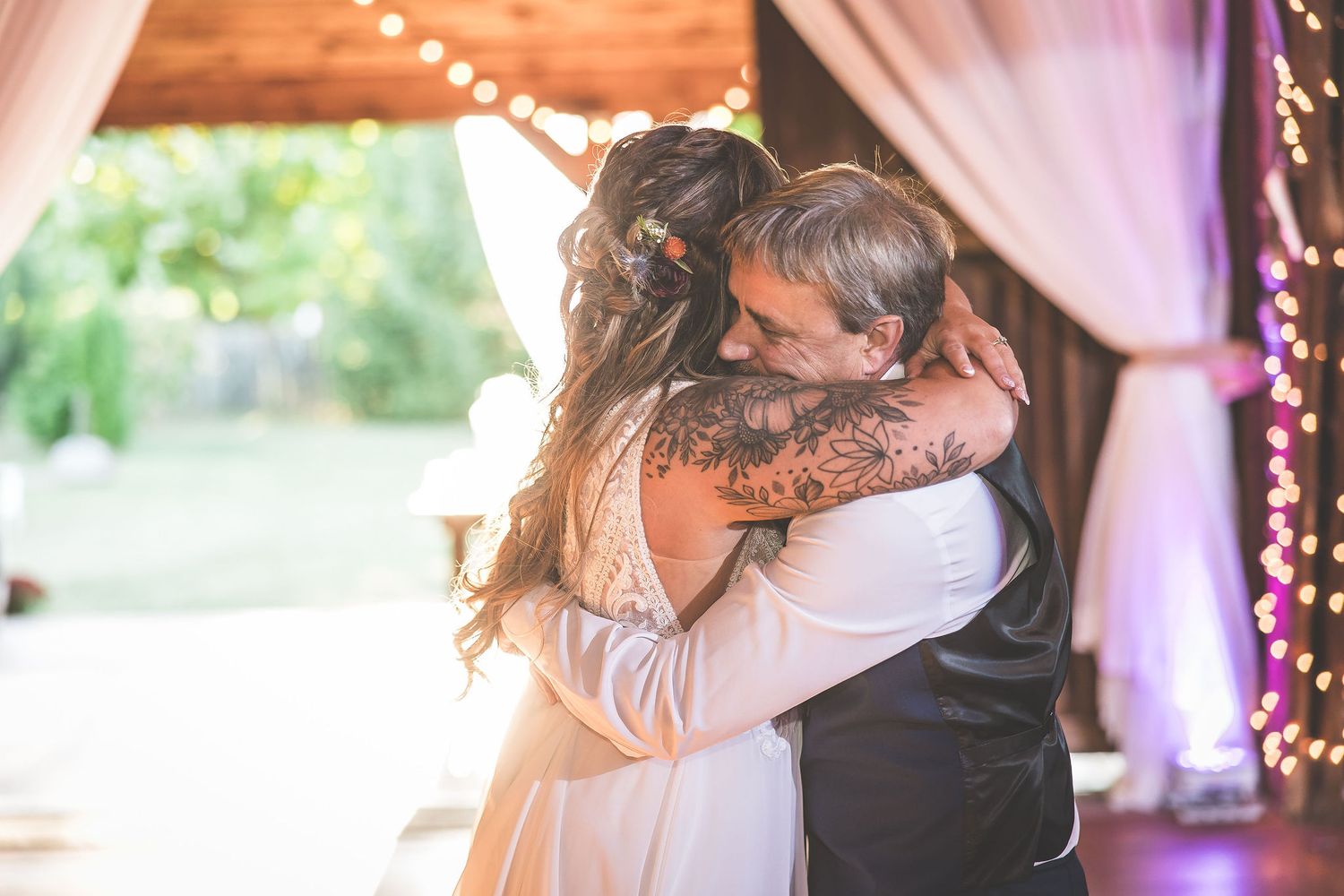 Romantic dance sequence captured under twinkling lights in a rustic barn setting.