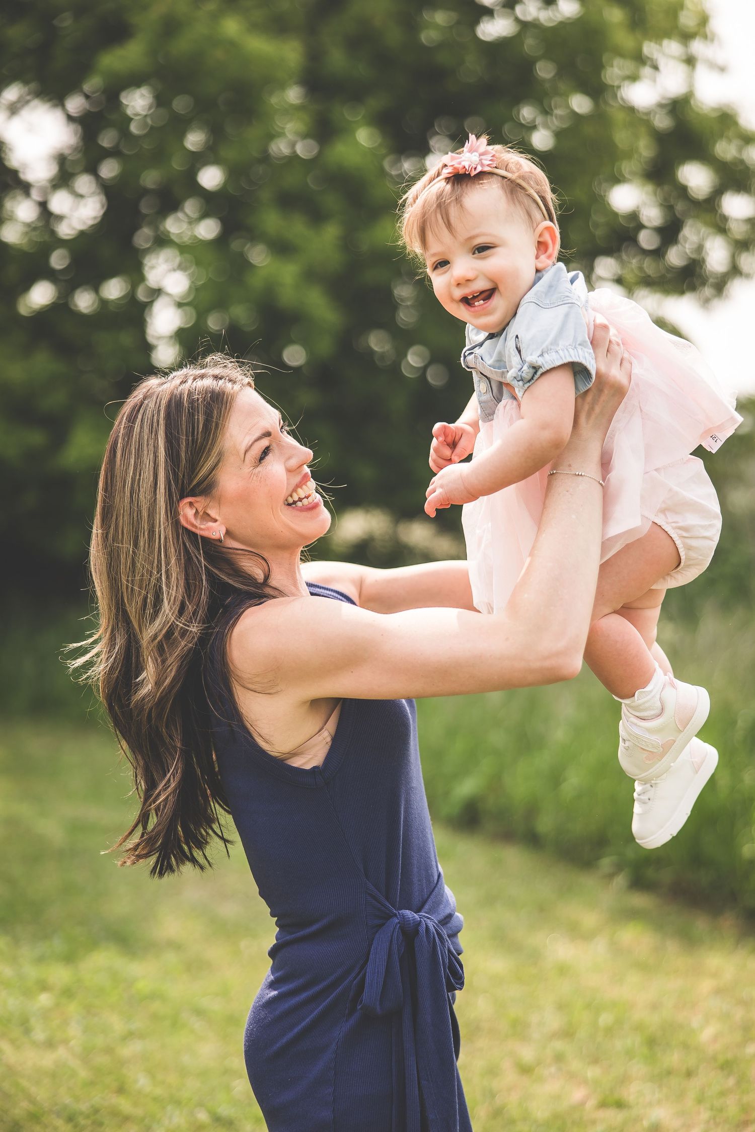 A joyful moment captured between parent and laughing baby in an outdoor setting.