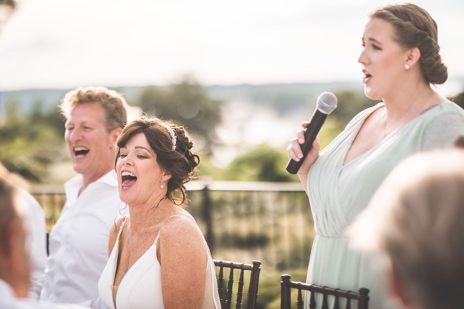 Candid moments of laughter and joy during wedding reception speeches.