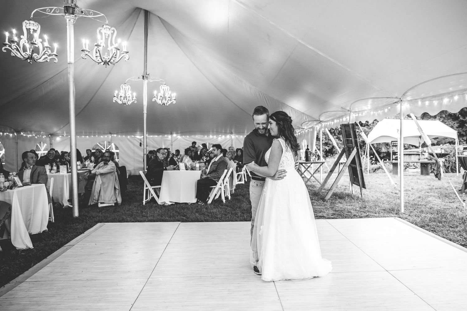 Wide shots of an elegant wedding reception setup under a white tent with chandeliers.