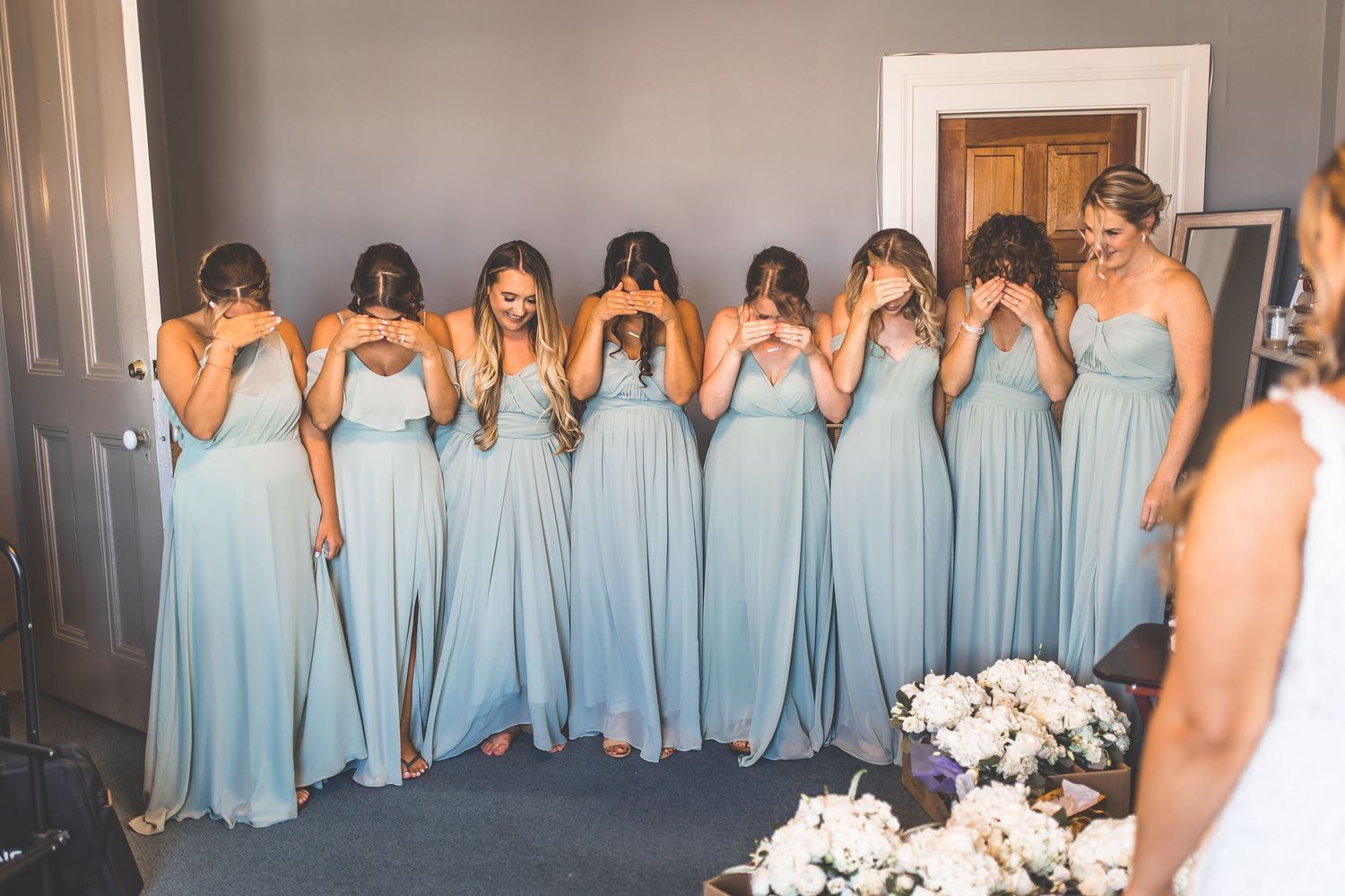 Row of bridesmaids in light blue dresses standing together for a wedding photo.