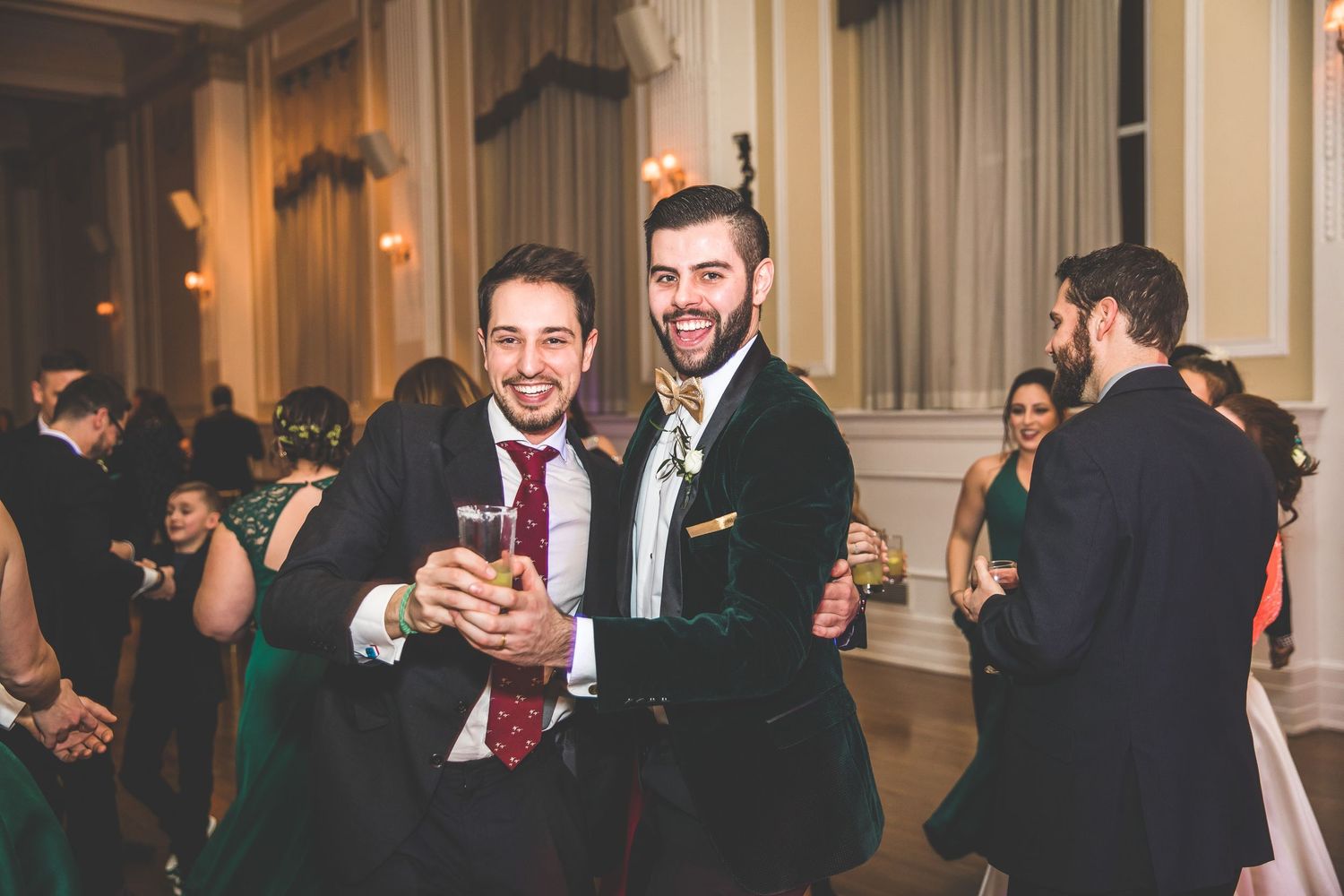 Wedding guests mingle and socialize during an indoor reception in an elegant venue with classic decor.