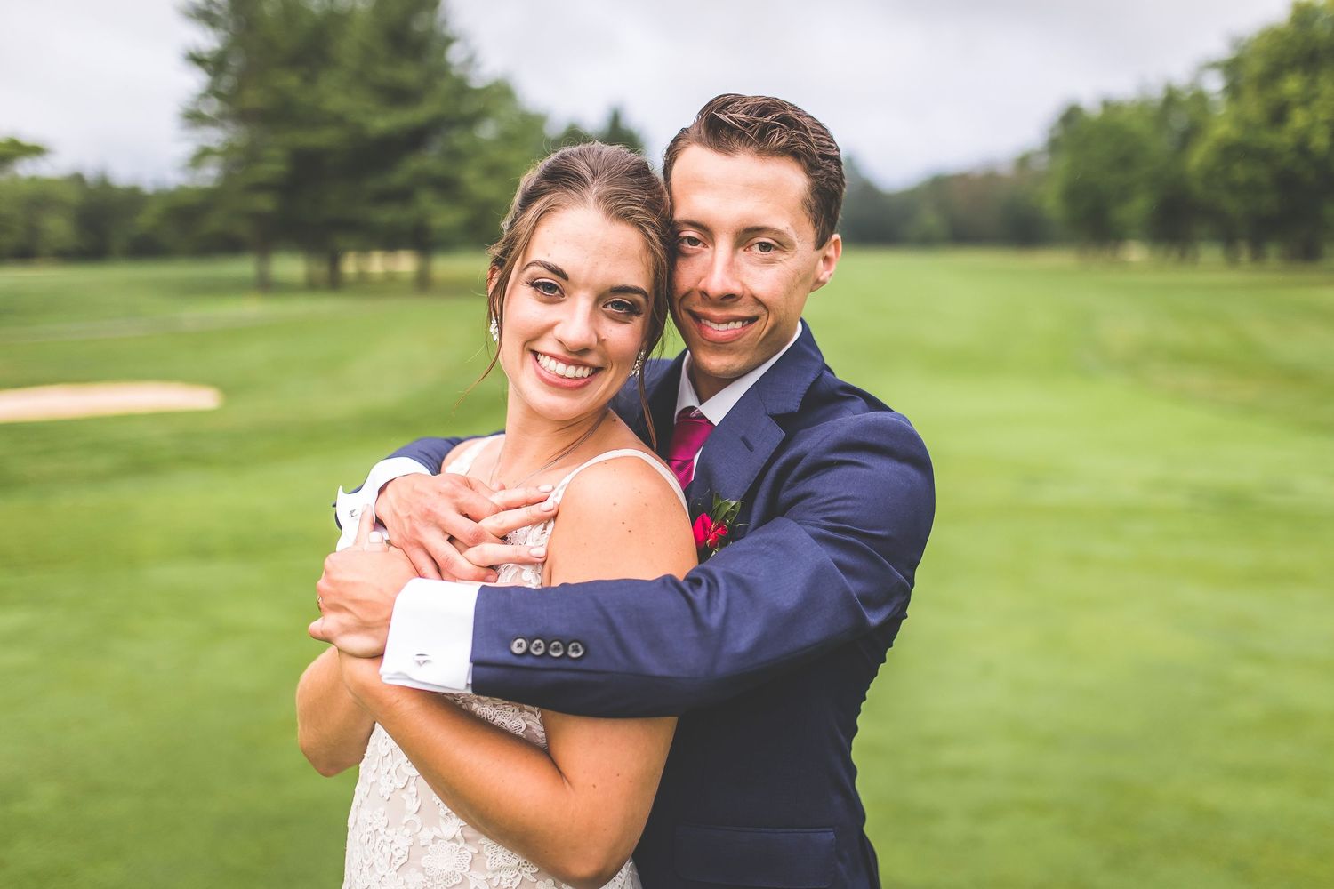 Romantic wedding portraits captured on a lush golf course with natural lighting.