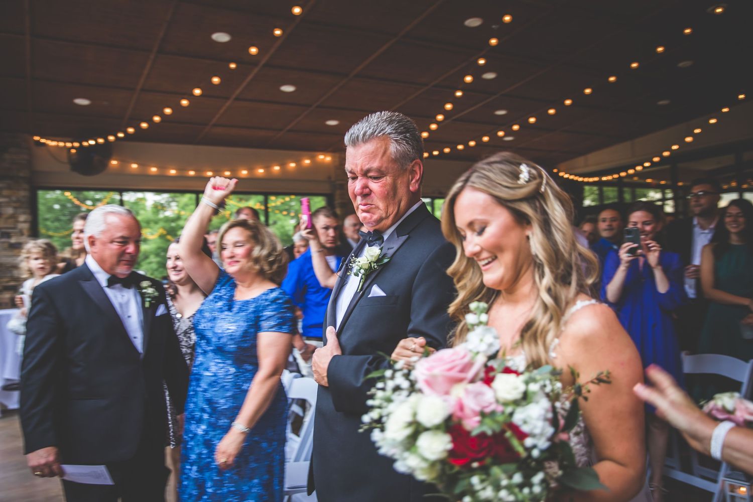 Wedding celebration in a rustic venue with string lights and stone walls.
